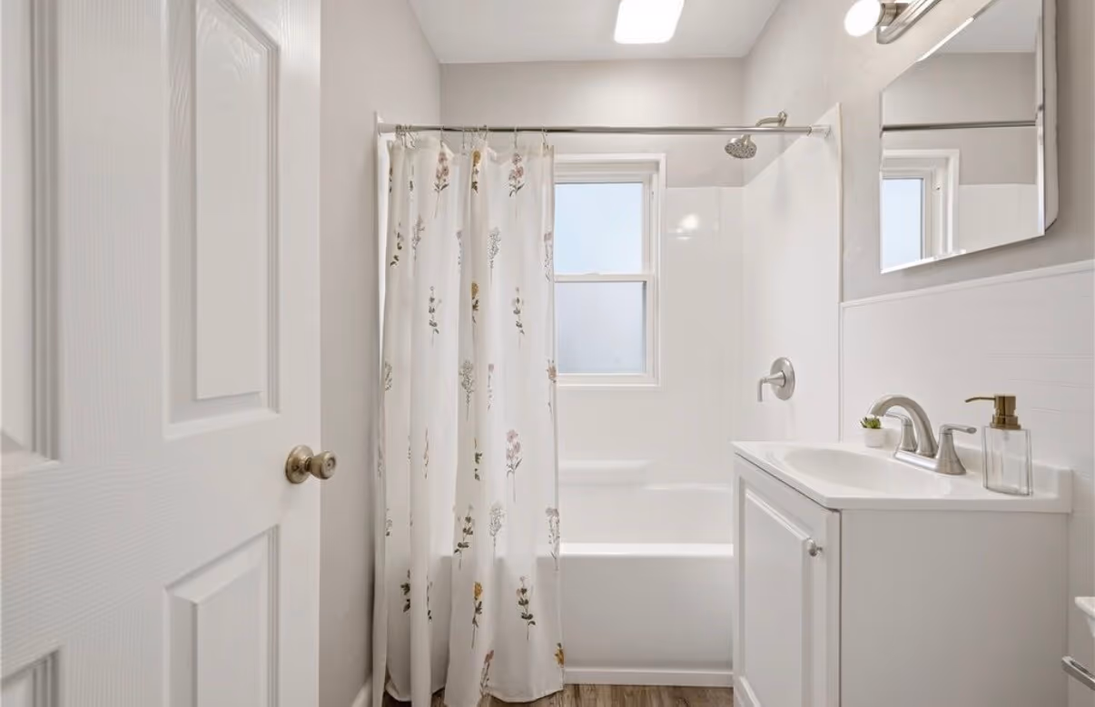 Finished bathroom with a shower, pedestal sink, and built-in storage