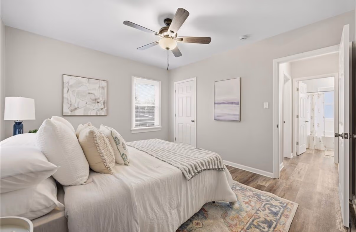 Finished master bedroom, staged with a bed and decor
