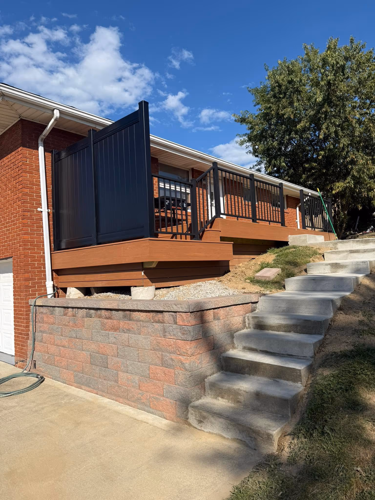 Finished deck above a retaining wall and concrete stairs