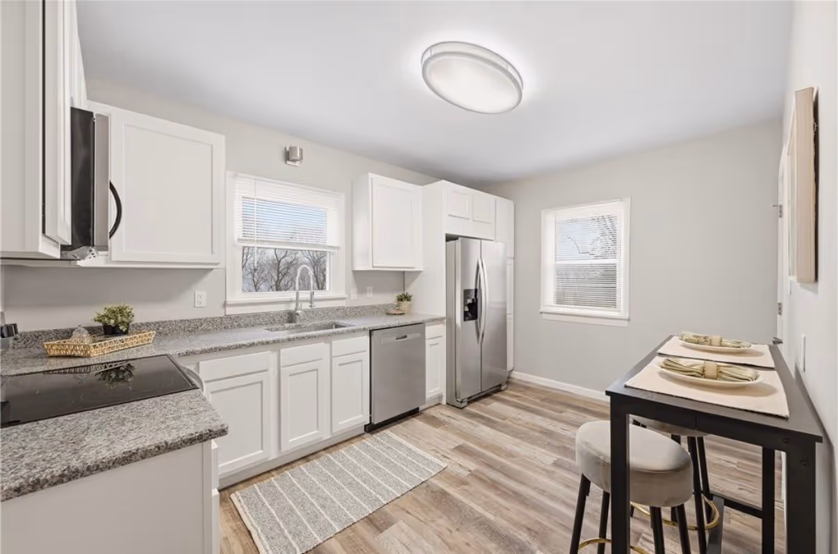 Finished kitchen remodel with white cabinets, granite counters, and stainless appliances