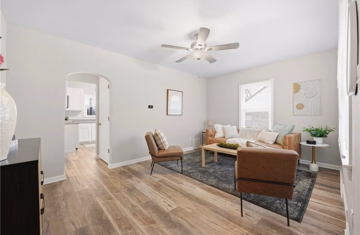 Finished living room with fresh paint, new flooring, and staged furniture